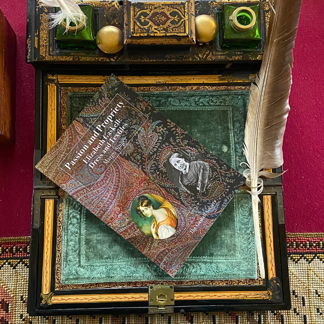 A copy of the book Passion and Propriety by Margo Singer, with a reddish cover and 2 pictures of Elizabeth Gaskell on the cover.