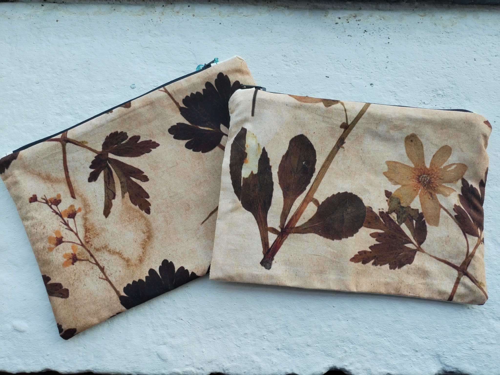 Trowbridge Herbarium Zipped pouch on a white brick background