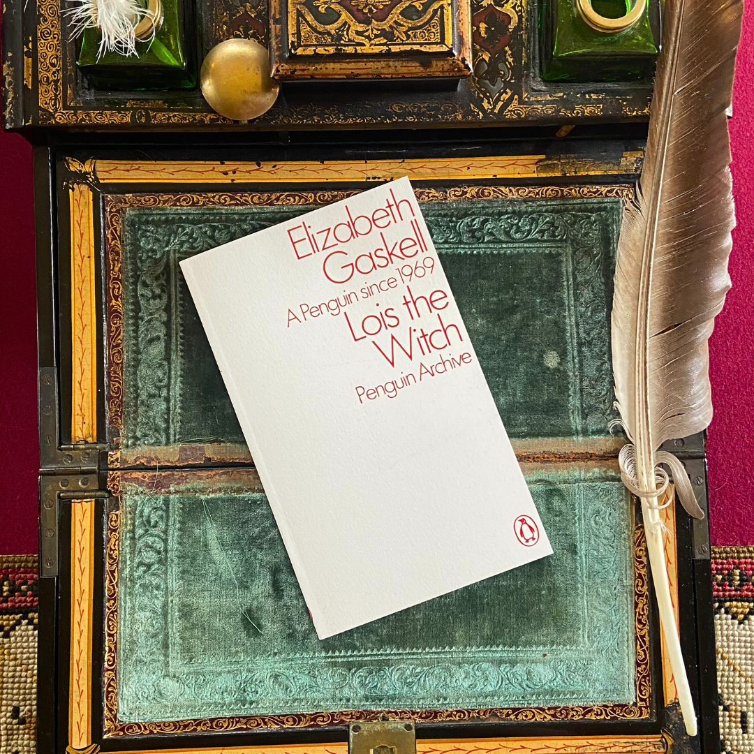 A copy of Lois the Witch by Elizabeth Gaskell, with a white cover reading Lois the Witch in red text.